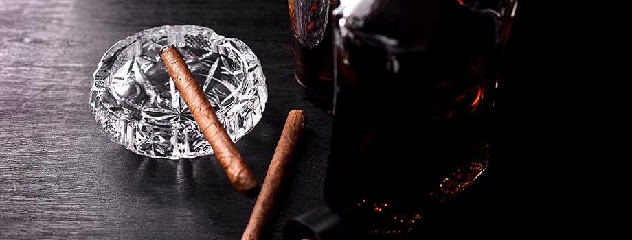 Glass of whiskey with cannabis blunts. How to roll a perfect blunt.