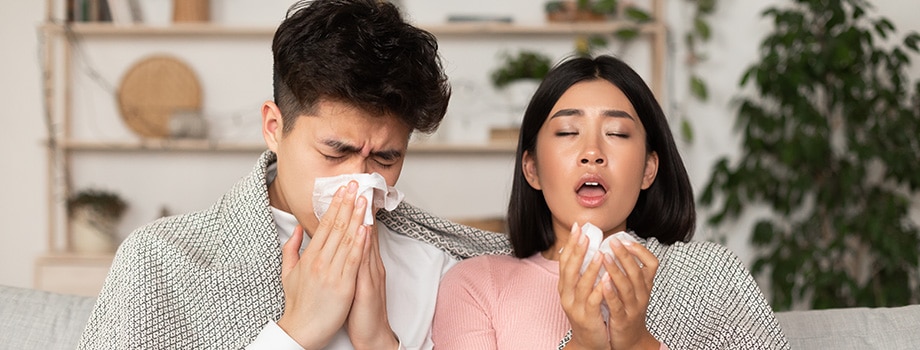 Sick Asian Couple Sneezing In Napkin Having Flu At Home